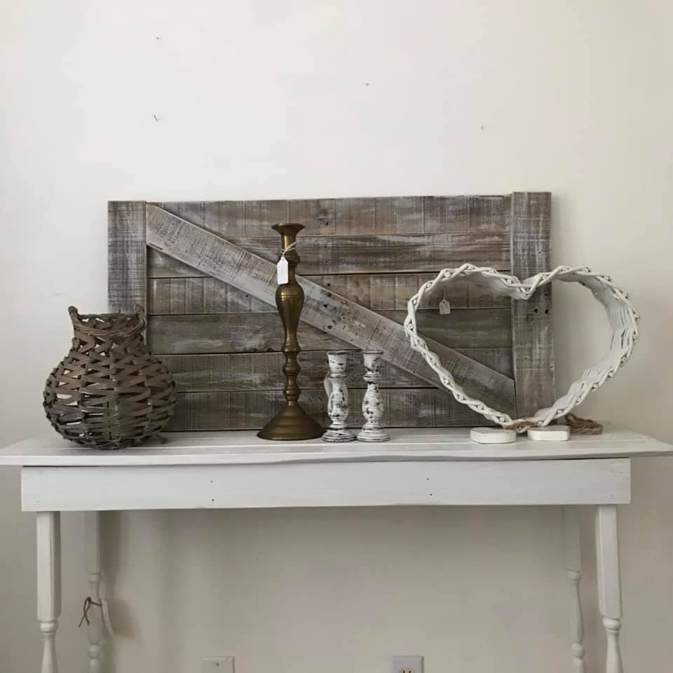 This white table shows a wooden sign and three candles